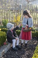 Kinder suchen Ostereier im Bauerngarten