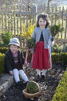 Children with palm bunches in the cottage garden