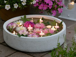 Flowers and floating candles in a wide shell