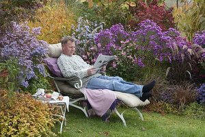 Lounger at the autumn border with asters and grasses
