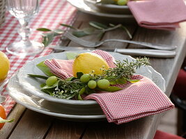 Tischdeko mit Zitrus-Früchten und Oliven