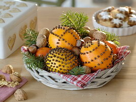 Small basket with pomander and mandarins (Citrus), nuts