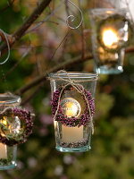 Small jars hung on a tree as lanterns