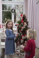 Mädchen mit stilisiertem Weihnachtsbaum als Adventskalender