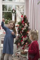 Mädchen mit stilisiertem Weihnachtsbaum als Adventskalender