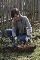 Frau jätet Unkraut im Bauerngarten