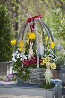 Egg-shaped Easter basket planted with Ranunculus (ranunculus), Bellis