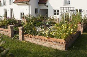 Small cottage garden with wall, fountain in the middle, paved paths