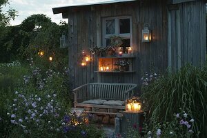 Gartenhaus in abendlicher Beleuchtung mit Laternen und Windlichtern