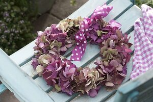 Kranz aus Blüten von Hydrangea (Hortensie) auf Stuhl