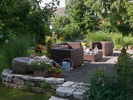 Seating group on wooden terrace with dry stone wall