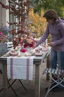 Herbstliche Rosen-Tischdeko auf der Terrasse