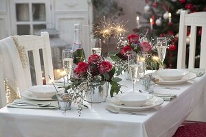 Festive New Year's Eve table decoration with bouquets of pink (roses), Cytisus