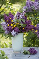 Fragrant bouquet of light and dark syringa with ranunculus