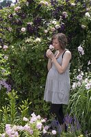 Pregnant woman enjoying the scent of pink (roses)