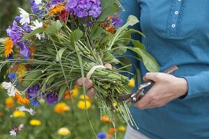 Woman tying colorful summer bouquet