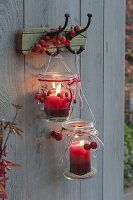 Old preserving jars hung on coat hooks as lanterns