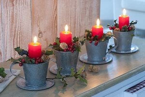 Unusual Advent wreath made of single zinc cups, red candles, holly