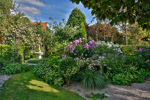 Lawn path between beds leading to fountain