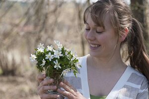 Woman with a little Anemone nemorosa (Wood anemone) bouquet