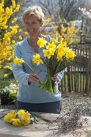 Woman ties a bouquet of narcissus