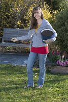 Woman is fertilizing grass by hand