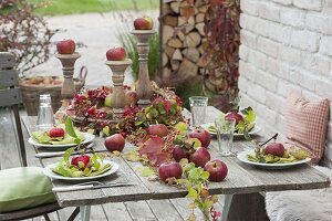 Tischdeko mit Äpfeln, Hagebutten und wildem Wein