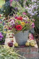 Rustic bouquet of zinnia and grasses in wicker vase