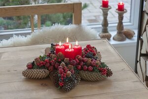 Pine cone star with fruits and berries as Advent wreath