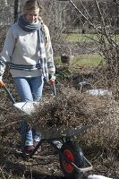 Frau macht Frühjahrsputz im Garten