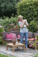 Lounge-Ecke auf kleiner Terrasse zwischen Rosen