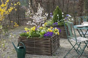 Gravel terrassse with raised beds made of hazelnut rods