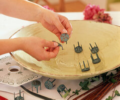 Stick rose fans. Put the pinholder in a tray to stabilise the sponge.