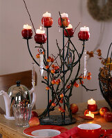 Kerzenständer mit Zweigen und Malus (Zieräpfel)