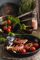 Fried octopus with tomatoes and capers in a pan