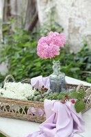 Hydrangeas, poppy seedheads and berries on wicker tray