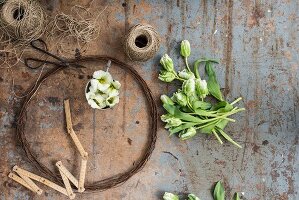 Kranz aus rostigem Draht, Blumen und Paketschnur auf abgenutzem Tisch