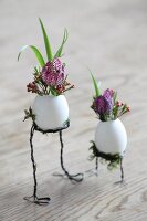 Flowers arranged in blown eggs on wire legs