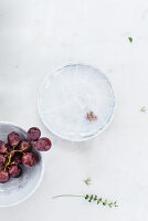 Bowl of grapes and herb flowers on plate