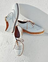 Various white lace-up brogue-style shoes with typical perforated pattern