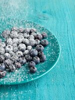 Blueberries on blue plate on blue table