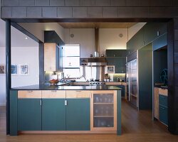 Open-plan kitchen with teal cupboards