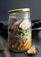 Roasted duck breast with buckwheat, grilled sweet potatoes and green beans in a glass jar
