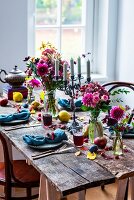 Gedeckter Holztisch herbstlich rustikal dekoriert mit Blumen und Früchten