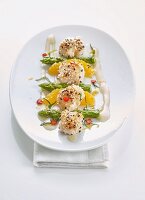 Scallops in a sesame coating with green asparagus and oranges