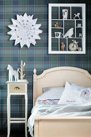 Display case on blue tartan wallpaper in vintage-style child's bedroom