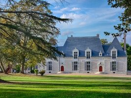 Das Château Des Grotteaux mit Anlage und blauem Himmel