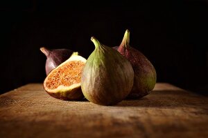 Fresh figs, whole and halved, on a wooden table
