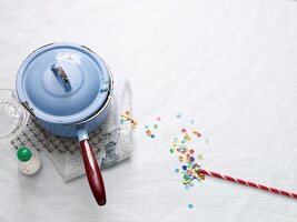 A pan with handle and a straw with confetti