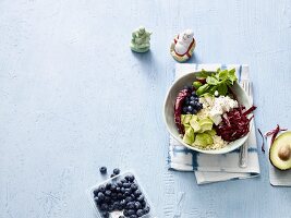 A Buddha bowl with couscous, avocado, blueberries and soft goat's cheese